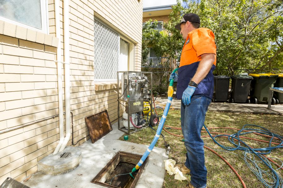A man cleaning drainage system in backyard