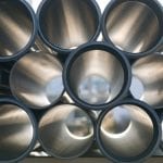 Stack of gray PVC tubes plastic pipes